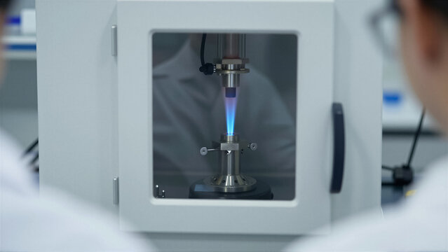 Detailed view of a blue flame combustion test in a laboratory chamber. Scientists conduct a scientific experiment for chemical research and industrial quality control