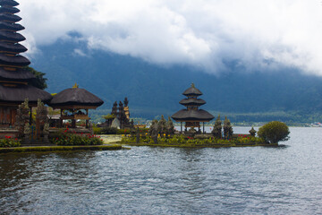 Obraz premium Ulun Danu Beratan Temple floating on Lake Beratan in Bali, Indonesia, with misty mountain backdrop.