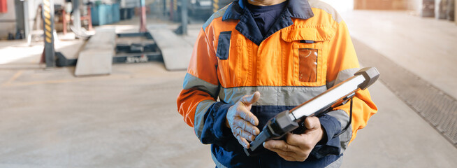 Fototapeta premium Mechanic using tablet for vehicle diagnostics in service bay for truck mining