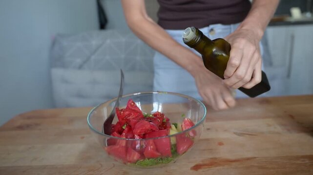 Fresh tomato herb salad being seasoned with oil in glass bowl video Full HD