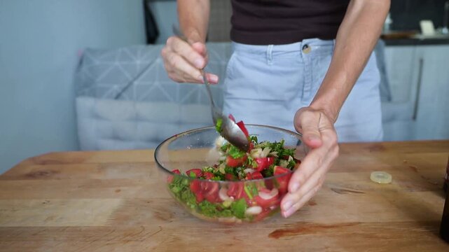 Mixing fresh tomato herb salad in glass bowl during meal preparation video Full HD