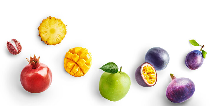 Flat lay of fresh fruits with hard flash shadow isolated on a white background. Lychee, pineapple, pomegranate, mango, apple, passion fruit, fig and plum bottom border with copy space.