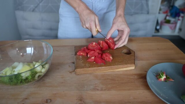 Woman cutting ripe red tomato into pieces for fresh homemade vegetable Full HD salad video