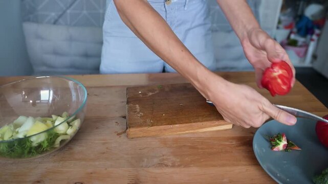 Woman cutting ripe red tomato into pieces for fresh homemade vegetable salad video Full HD