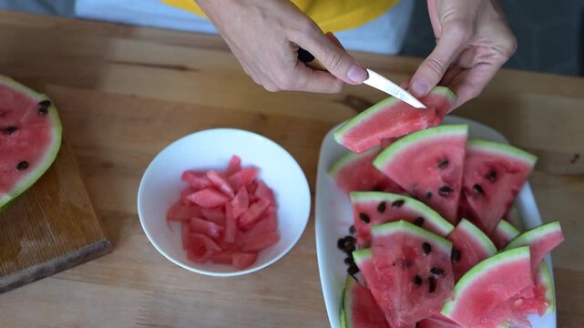 Woman removing knife after cutting watermelon into equal slices at Full HD video home