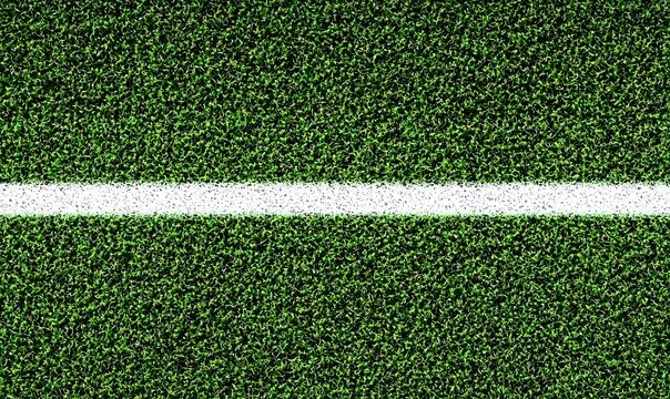 Close up of green artificial turf with white line on sports field.