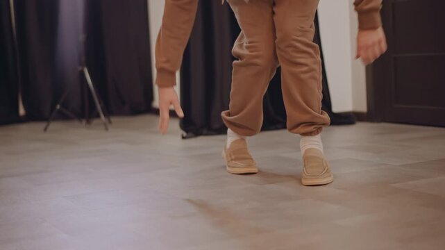 White dancer practicing precise footwork on studio floor, closeup feet and sneakers, controlled heel and toe technique, partner moving into frame, timing and sync emphasized, parquet reflections