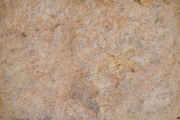 Obraz premium Rough natural stone surface texture with light brown and beige tones.