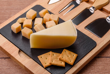 Fototapeta premium Aged cheese in a triangular block with jam, figs, and nuts. Aged cheese