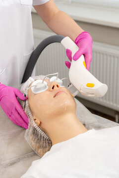 woman receiving facial treatment with device