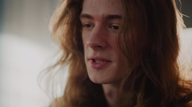 Male student receiving vocal lesson sunlight, sidelit closeup showing expressive mouth and steady breath, mentor feedback implied through attentive posture, classroom loft with window backlight, calm