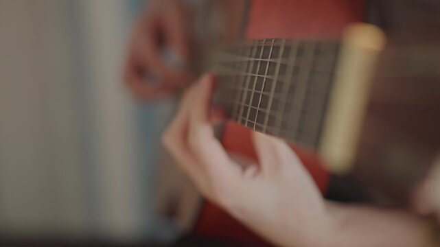 Gentle guitar practice session. Close view of fingers on guitar strings during soft practice. Detailed image capturing precise fingertips pressing nylon guitar strings in calm setting
