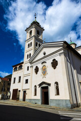 Fototapeta premium White facade of the Santa Maria del Ponte church seen through an alleyway in the city center of Susa