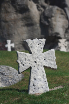 Ancient stone Cossack cross standing on a grassy hill under a bright blue summer sky
