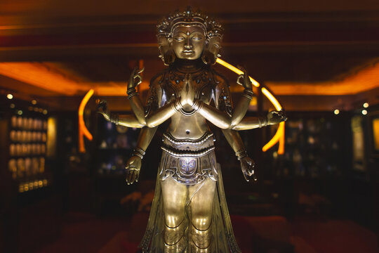 Golden statue of Avalokiteshvara or a multi-armed deity in a museum