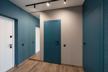 Fototapeta premium Modern hallway interior with blue accent walls and floor-to-ceiling mirror