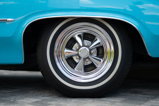 Close-up of a classic car chrome wheel with whitewall tire