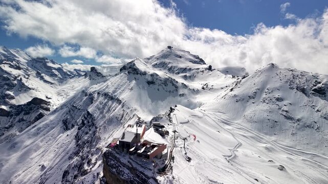 Aerial drone flying over snowy mountain peak in the Swiss Alps