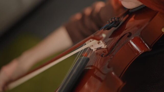 String technique closeup. Violin bowing and finger positioning. Close view of violin string and bowing detail. Comprehensive closeup capturing technique and craftsmanship of violin string play