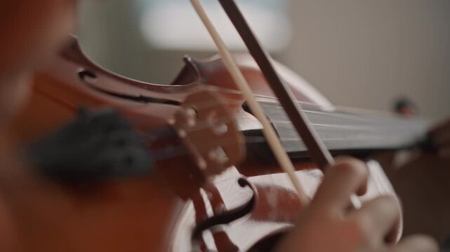 Closeup violin body and hands in lesson, redhead player focusing on fingerboard and bow contact, glossy varnish and bridge details, coachlike tutorial atmosphere in practice room, precise intonation