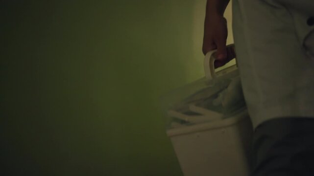 Nurse delivering medical cooler during home visit, steady hand on handle, warm hallway lighting and residential doorway, compassionate pace and routine outreach bringing medicines and samples