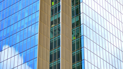 Obraz premium Modern office building with glass facade on a clear sky background. Transparent glass wall of office building.