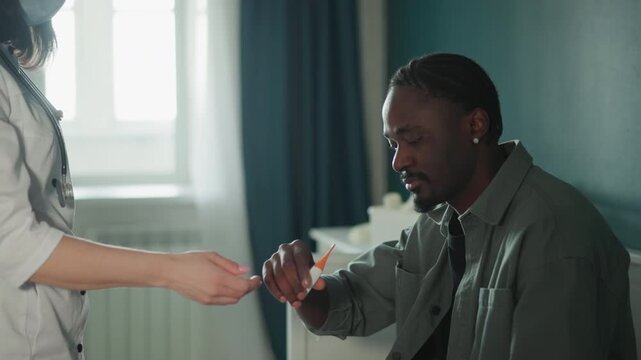 White nurse checks black patient home, masked clinician performs bedside assessment with stethoscope and medication, calm daylight interior, empathetic support and vital monitoring during home visit,