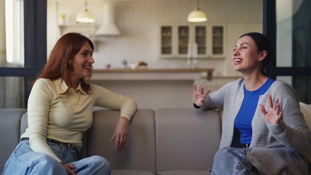 Cheerful woman in her 40s talking with best female friend, trusted friendship