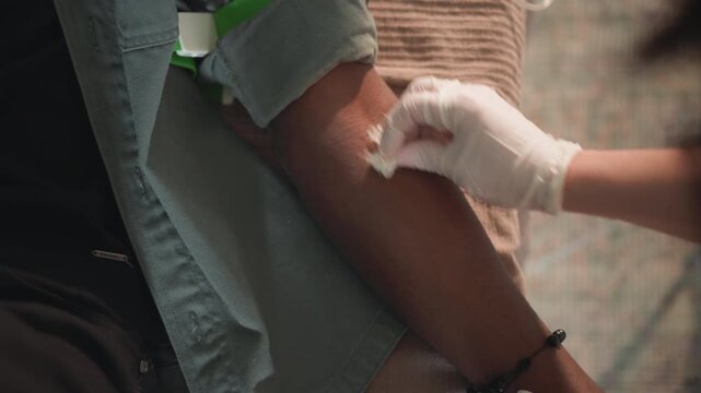 Blood draw preparation. Medical professional preparing patient for safe blood drawing process. Clinic staff member meticulously organizing tools for secure and sterile blood sampling