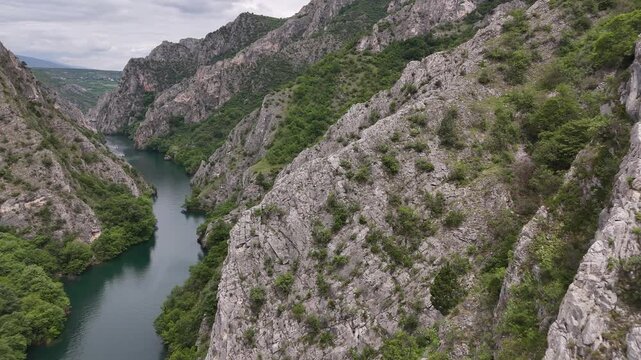 4K drone reveal flying over steep mountain cliffs to show Matka Canyon and Treska River, North Macedonia