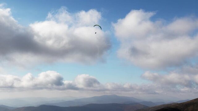People try paragliding flying with parachutes against clouds