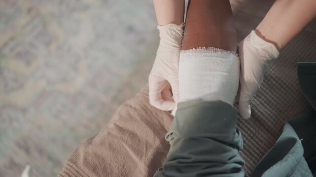 Compassionate helper carefully positions protective dressing for comfort and healing. Kind caretaker meticulously manages sterile covering to ensure patient comfort and expedite recovery process