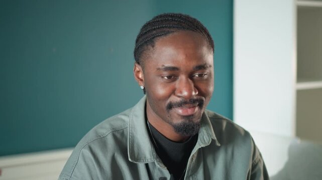 Black man home followup laughing patient portrait, candid series showing relief and rapport with visiting paramedic or clinician teal wall and bookshelf background, informal gestures, ear touch