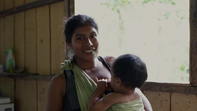 An indigenous mother from the Cab&eacute;car community in Costa Rica breastfeeding her baby in a baby carrier 