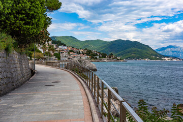 Fototapeta premium Seaside promenade of Herceg Novi curving beautifully along the deep blue waters of the Bay of Kotor, Montenegro