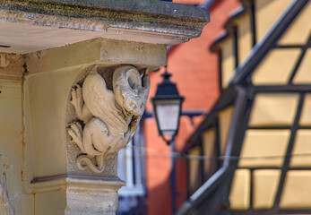 A winged gargoyle corbel carving on a building corner ledge in Colmar, France © SvetlanaSF