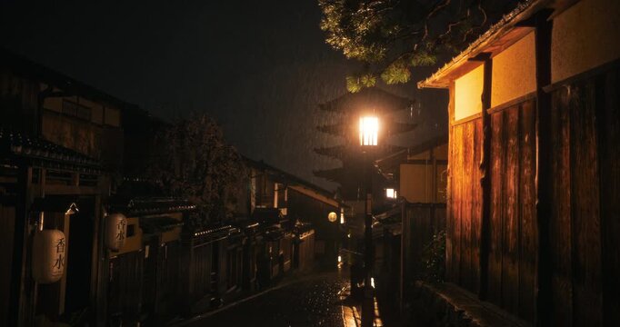 Heavy rain in empty, ancient, dark Japanese village with cobblestone road - wide, tracking shot