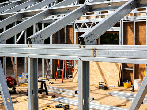 A construction site showing a house frame built with galvanized light gauge steel beams and trusses.