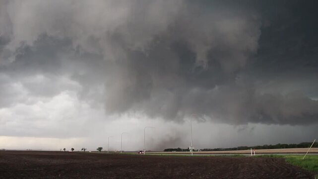 A wall cloud rotates strongly, kicking up dust as the storm attempts to form a tornado. Time lapse footage.
