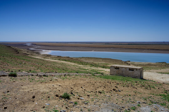 Amudarja or Amu Darya River, the Border between Uzbekistan and Turkmenistan with a Dilapidated Building on the Uzbek Side