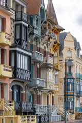 Obraz premium Houses of Mers-les-Bains, seaside town with 19th-century sea-bathing villas with colorful wooden balconies and white chalk cliffs, tourists destination in France