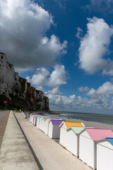 Obraz premium Views of ocean beach and colourful beach huts or cabins in Le Treport, seaside resort in Normandy, France, with white cliffs along English Channel, travel destination in France