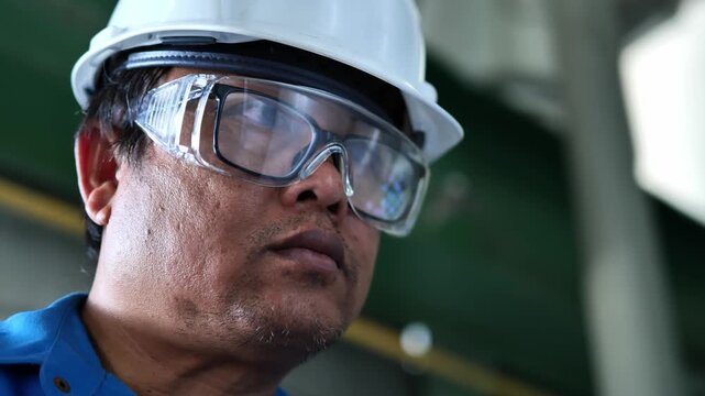 Experienced industrial professional standing in front of factory structures and process equipment showcases engineering knowledge, operational excellence, and commitment to workplace safety standards.