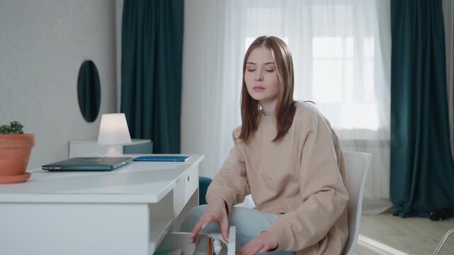 White woman at home desk tutor arranging grammar flashcards and laptop for remote lesson, cozy bright study room with plant and lamp, patient coach preparing notes and marking exercises, calm focused