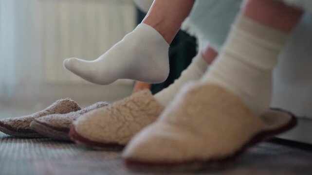 Cozy home feet in socks, student and tutor seated on rug for grammar lesson, slippers lined near chair, soft sunlight filtering through curtains, subtle foot movement indicating relaxed coaching, warm