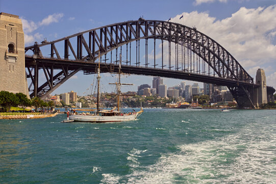 Sailing ship passing by Sydney Harbour Bridge, Australia