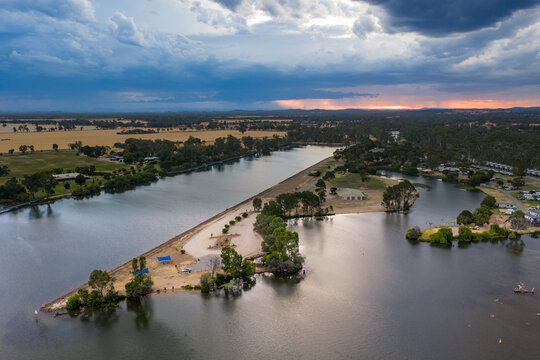 Aerial view of rain falling from dramatic storm clouds over a rowing course and inland river