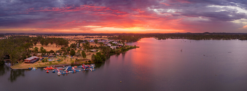 Aerial panorama view of colourful dramatic sunset over a water park on an inland lake