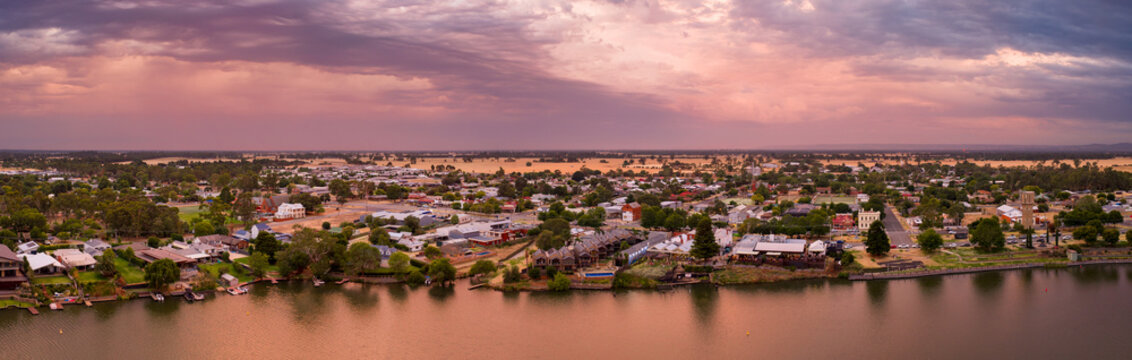 Aerial panorama view of colourful stormy sky over a rural town on the shores of an inland lake