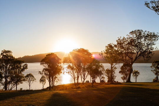 Cars parked at campsite alongside shore of inland water catchment lake